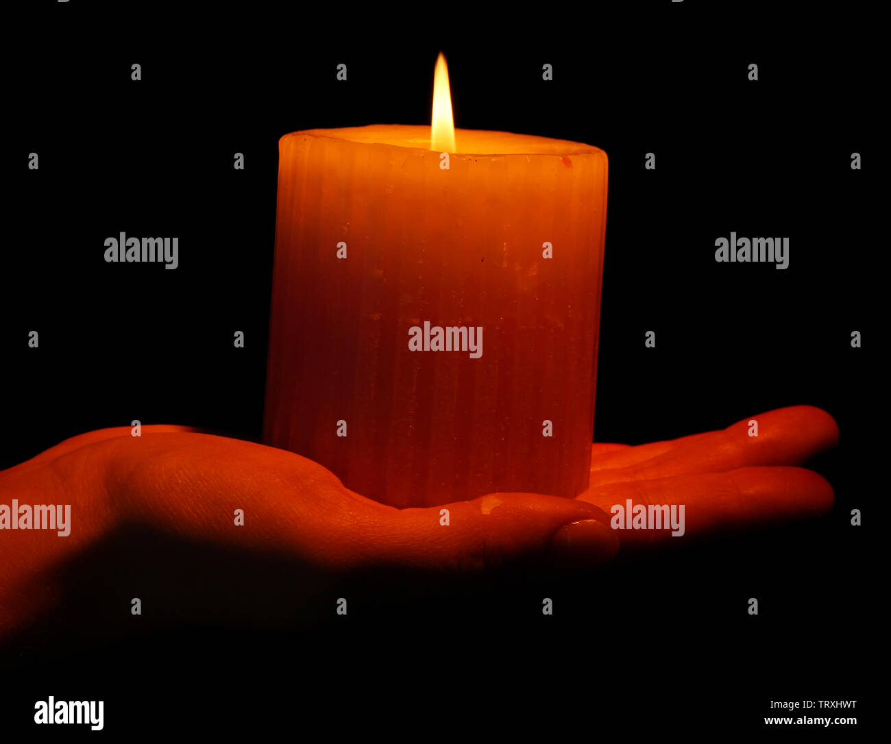 Burning candle in hand isolated on black Stock Photo