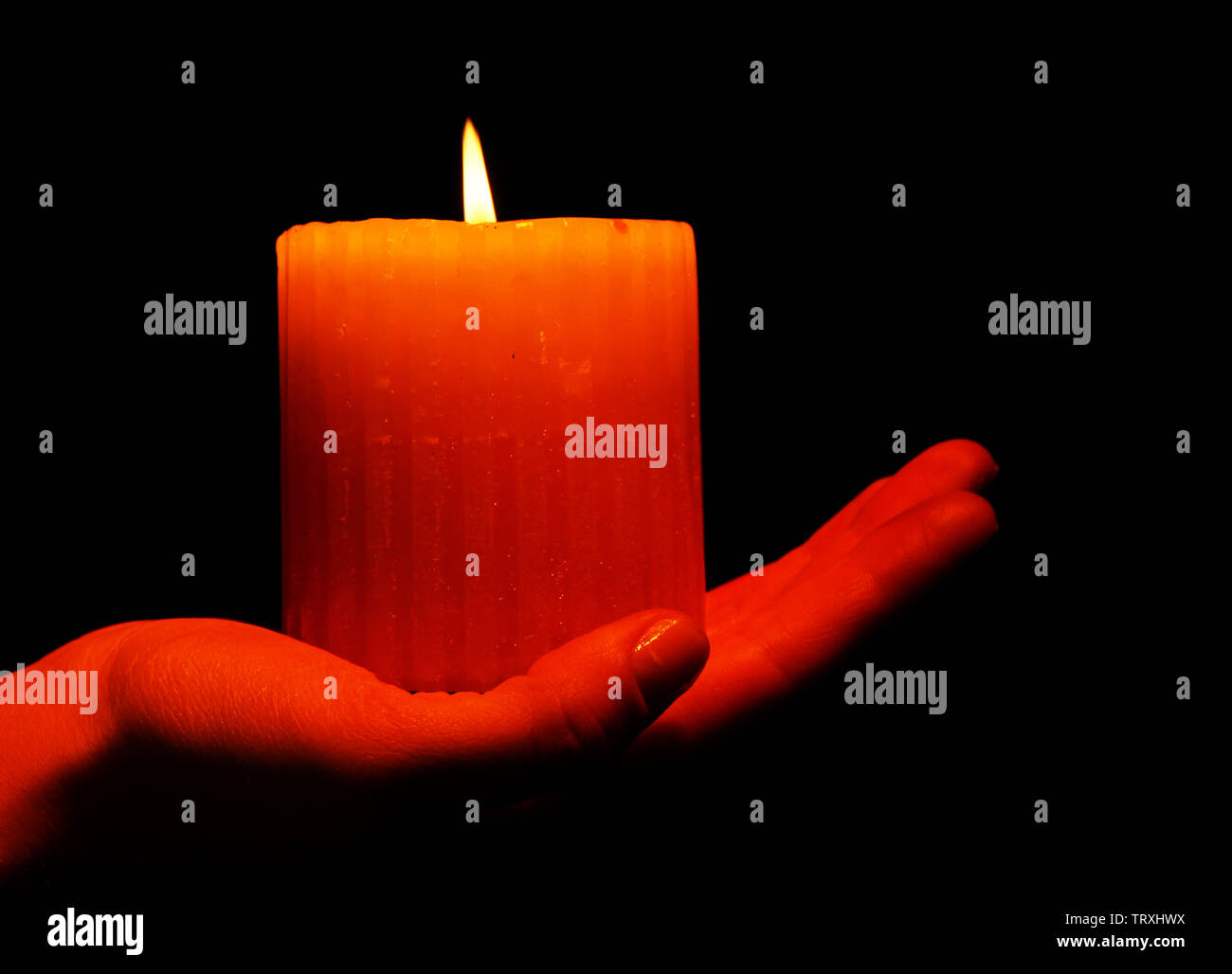 Burning candle in hand isolated on black Stock Photo