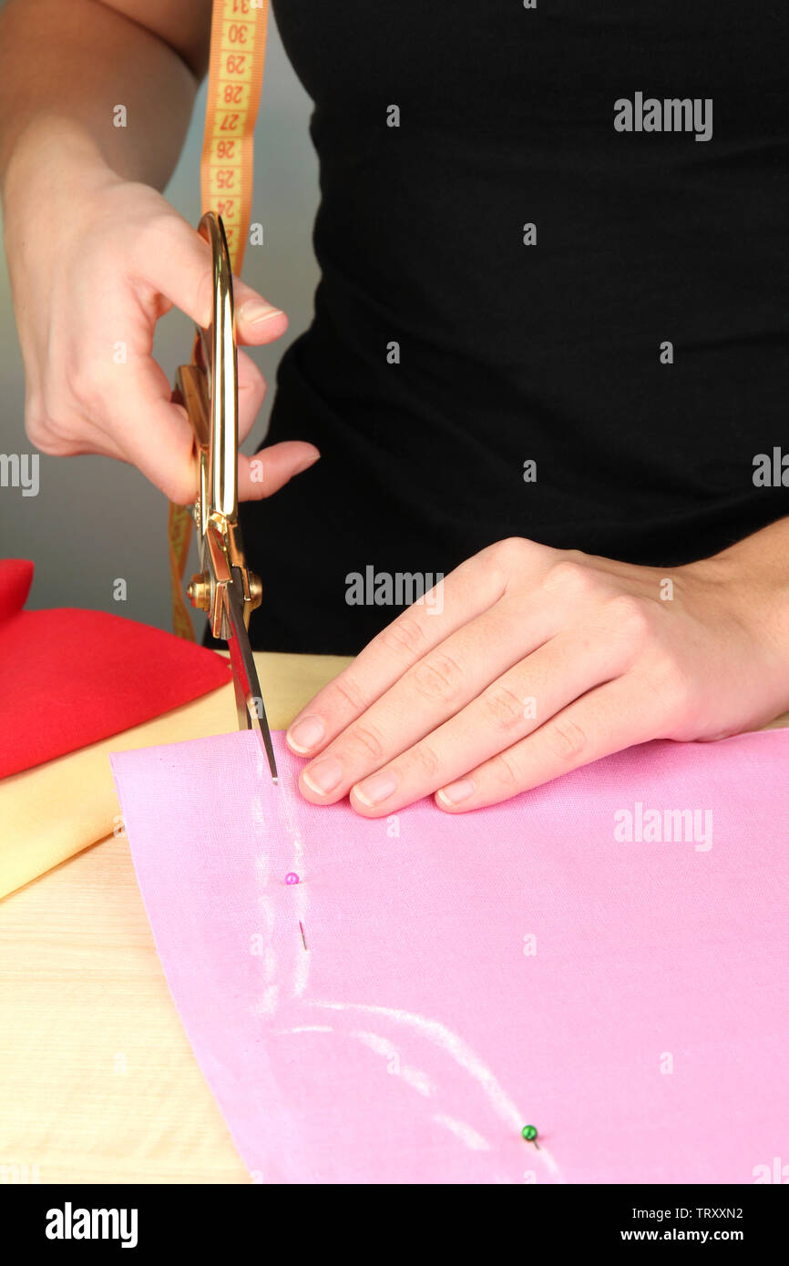 Cutting fabric with tailors scissors Stock Photo Alamy