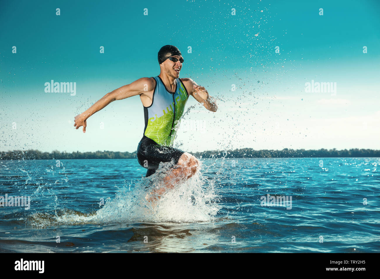 Professional triathlete swimming in river's open water. Man wearing swim equipment practicing