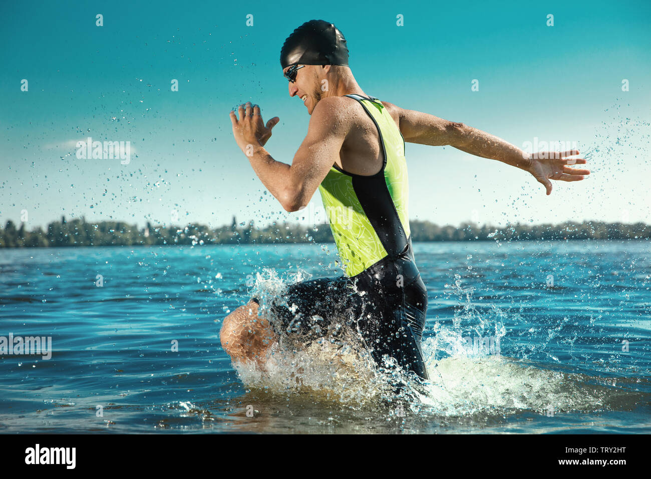 Professional triathlete swimming in river's open water. Man wearing swim equipment practicing