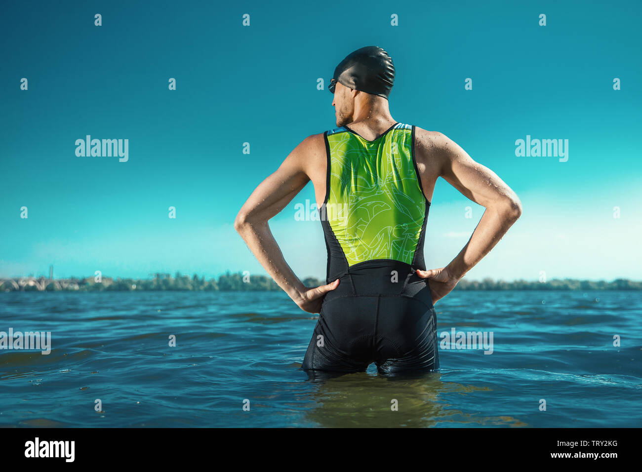 Professional triathlete swimming in river's open water. Man wearing swim equipment practicing