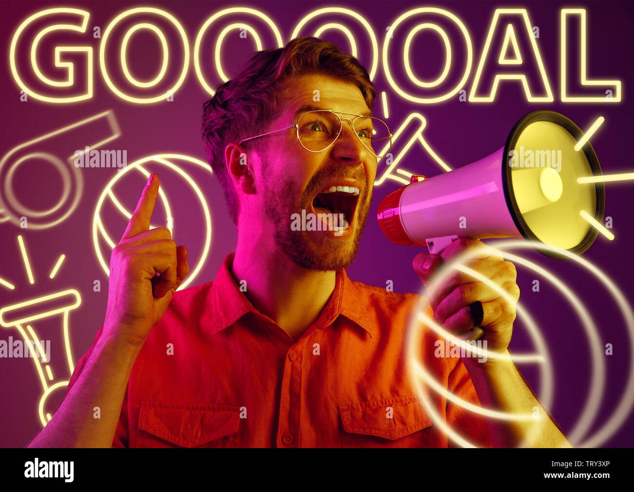 Young man as a sport's fan on purple background in neon light. Male model screaming, cheering for the favourite football or soccer team. Concept of facial expression, summer, vacation, sport, betting. Stock Photo