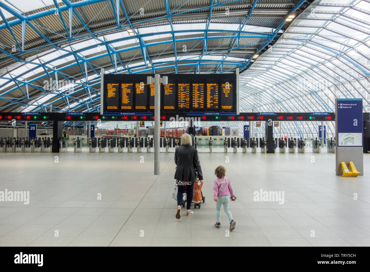 A mother and child waiting for a train at the former Eurostar Waterloo International Terminal, now reopened for Network Rail train services Stock Photo