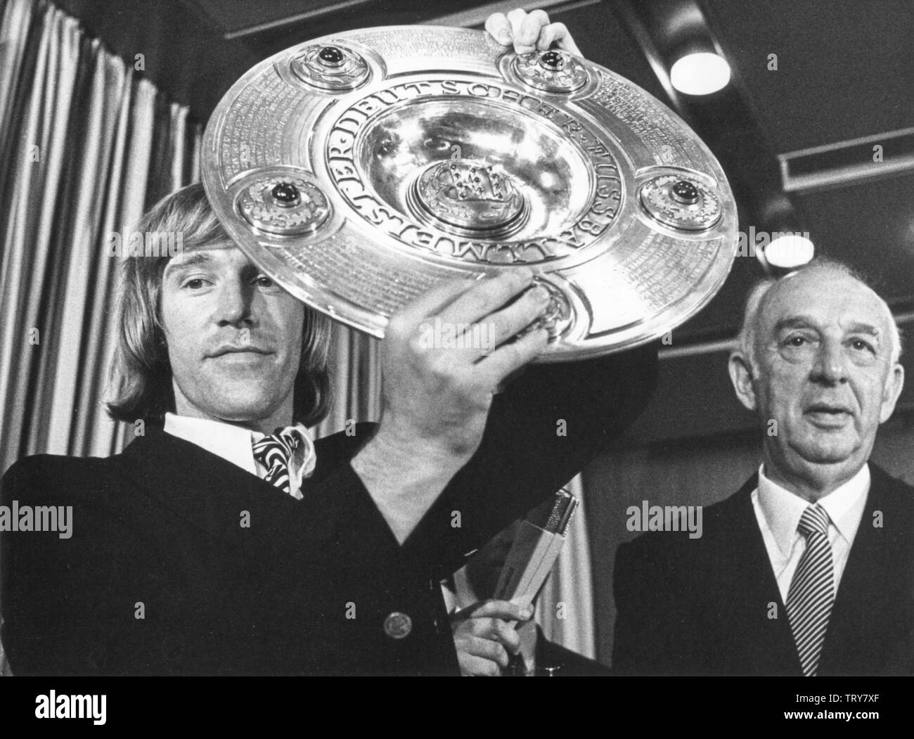The captain of Borrusia Mönchengladbach, Günter Netzer, on 5 June 1971 in Frankfurt with the championship bowl presented by DFB President Hermann Gösmann (r). Netzer was born on 14 September 1944 in Mönchengladbach. | usage worldwide Stock Photo