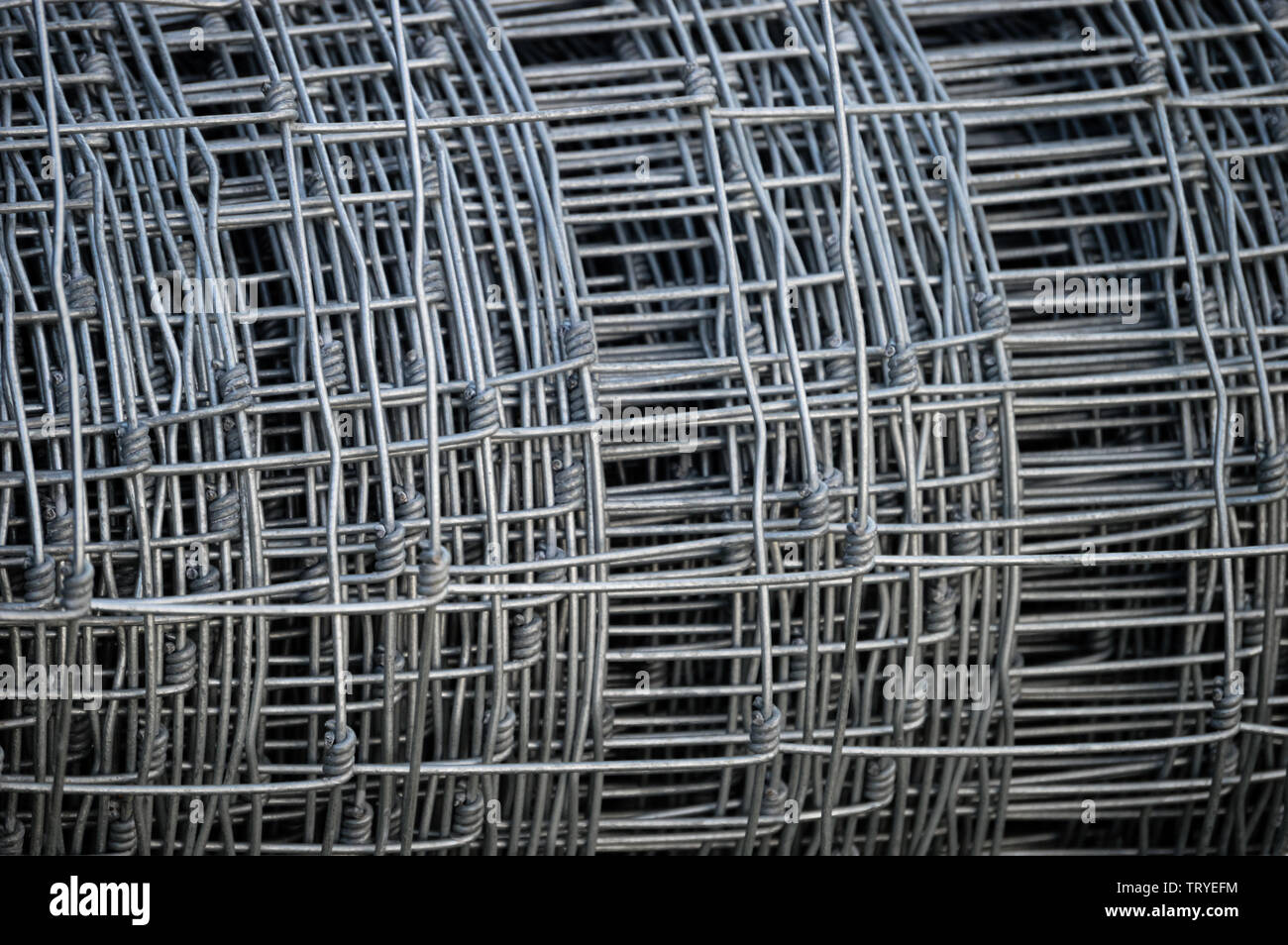 Closeup of a silver roll of galvanised steel metal sheep wire netting used for fencing livestock and crops Stock Photo