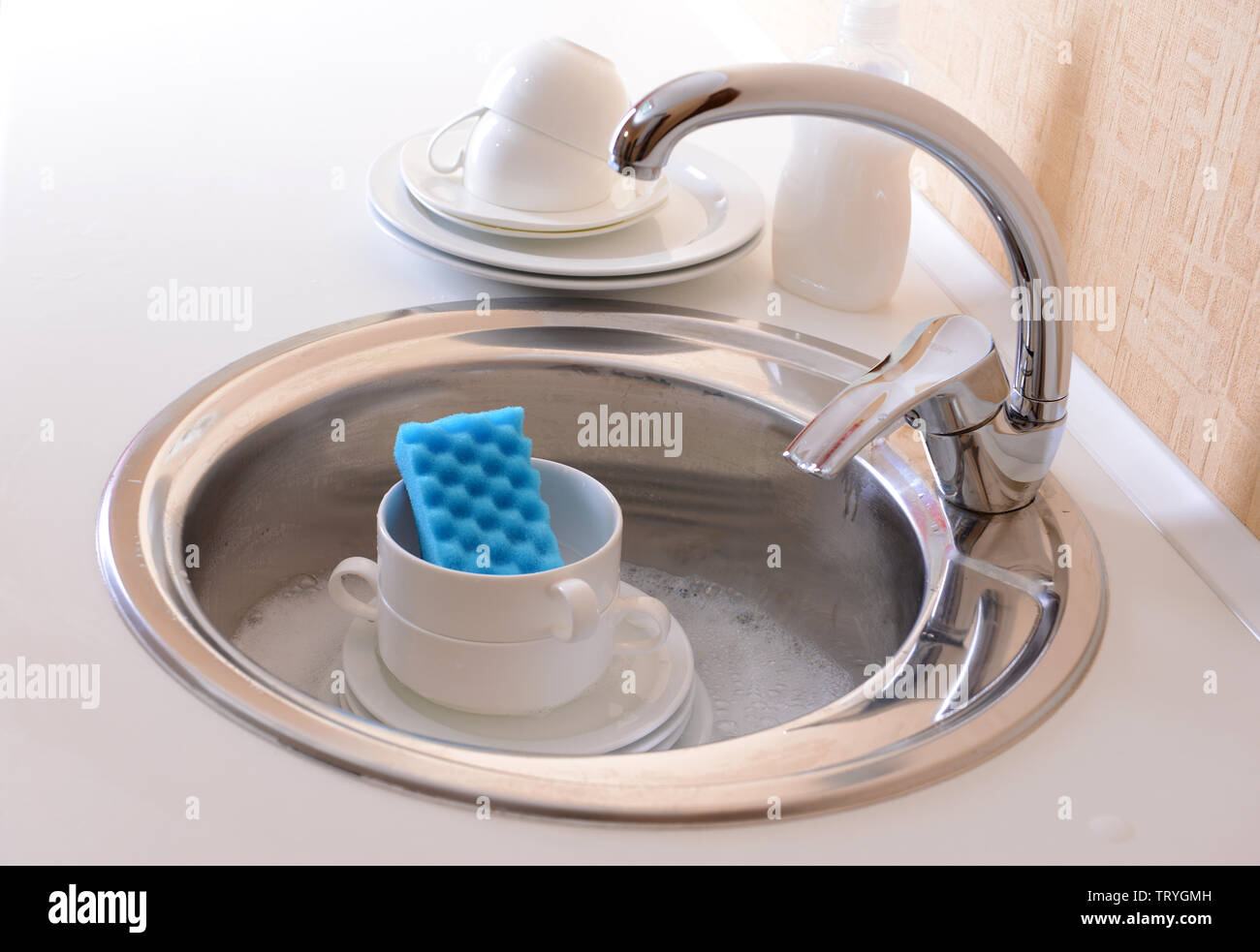 Stack of dishes soaking in kitchen sink Stock Photo Alamy