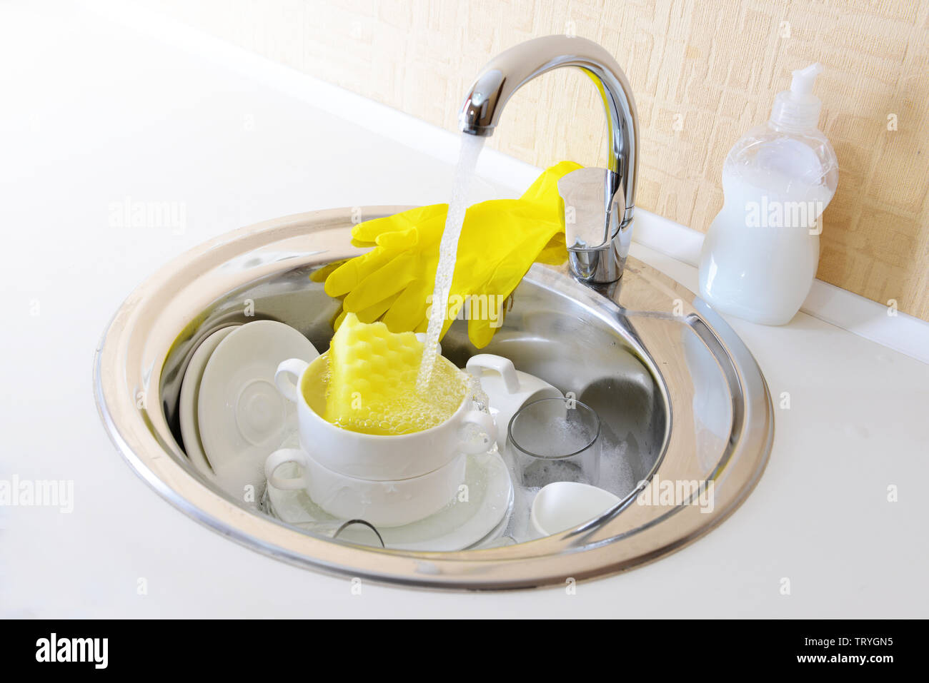 Stack of dishes soaking in kitchen sink Stock Photo Alamy
