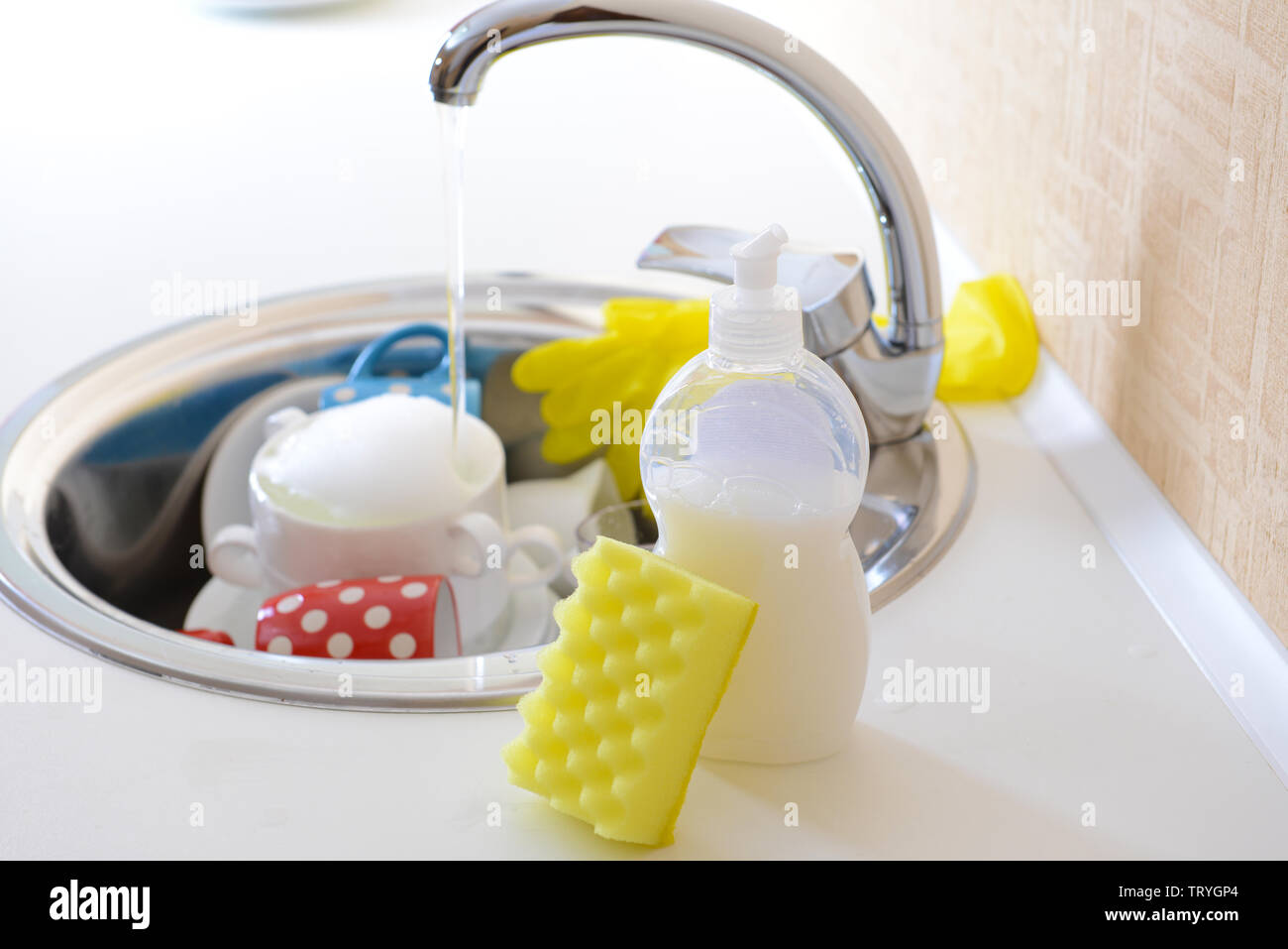 Stack of dishes soaking in kitchen sink Stock Photo Alamy