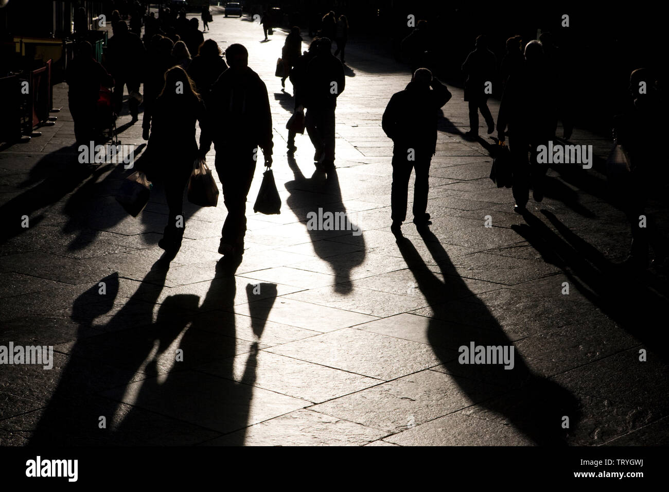 The long shadows of shoppers in a high street in Newcastle upon Tyne, England Stock Photo