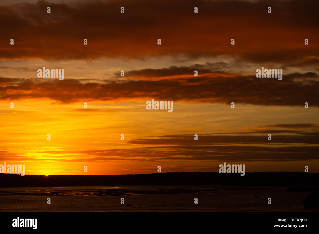Tranquil sunset over the lake. The whole scene covered in golden colors. Water calm. Concept of tranquility. Vacation landscape. Stock Photo