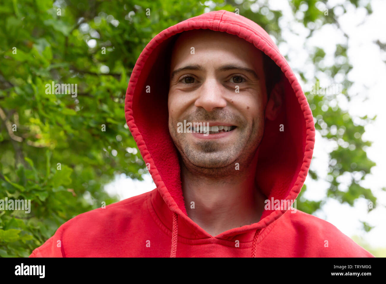 Portrait from young handsome guy wearing a red hood Stock Photo Alamy