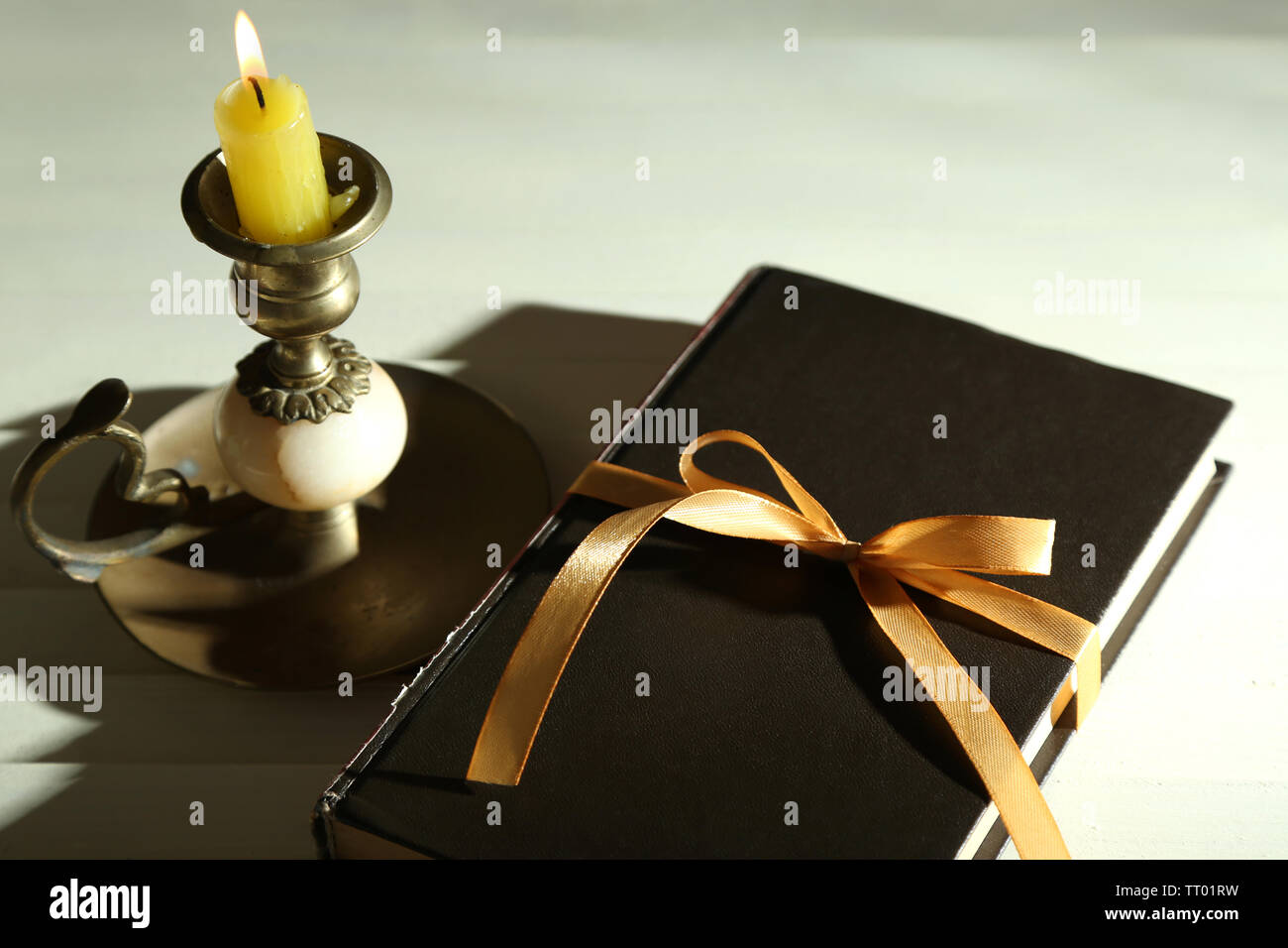Book wrapped with color ribbon, on wooden background Stock Photo - Alamy