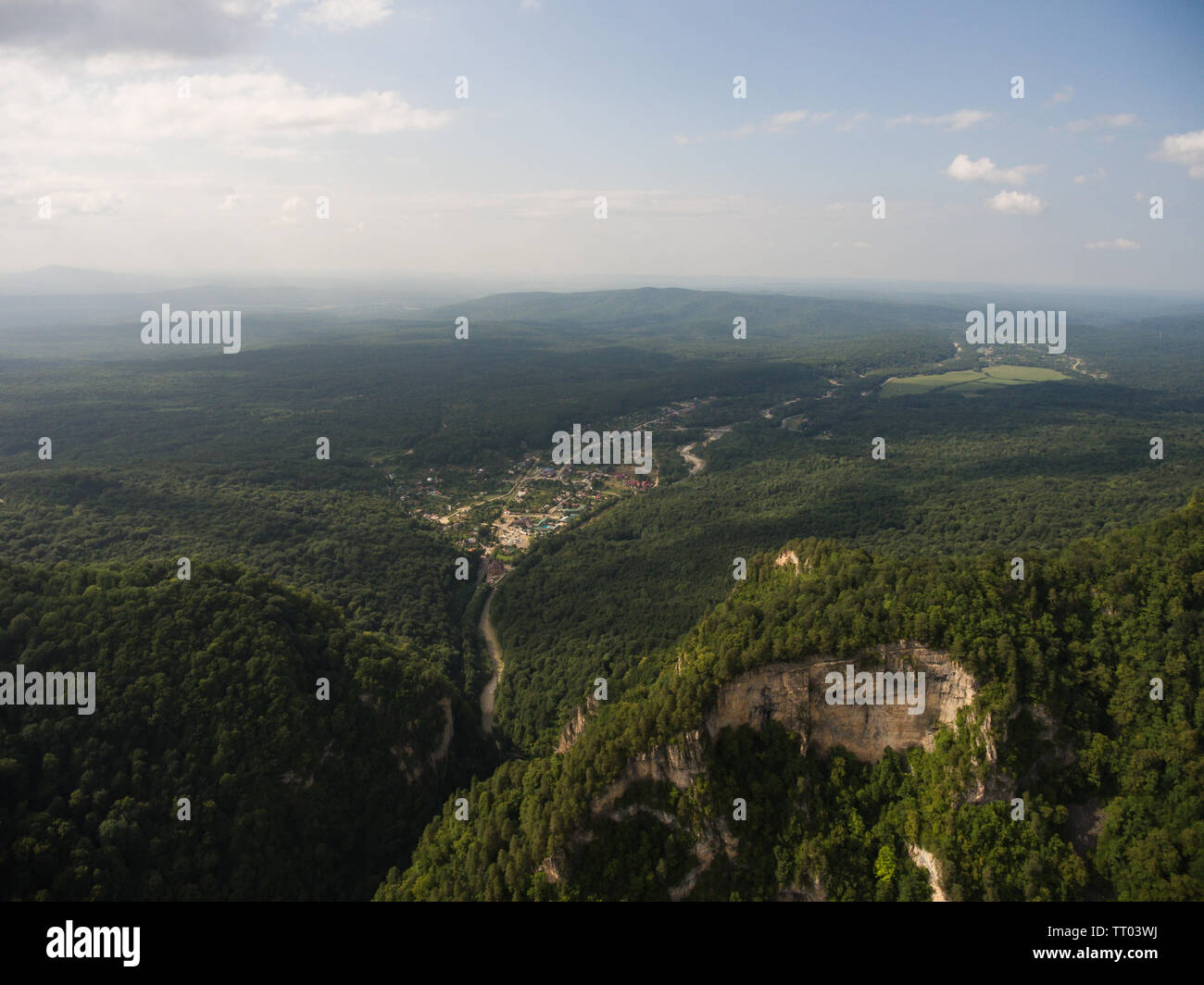 Photo made drone. A view of a large wooded hill and village Guamka. Krasnodar region,  Caucasus Mountains. Stock Photo