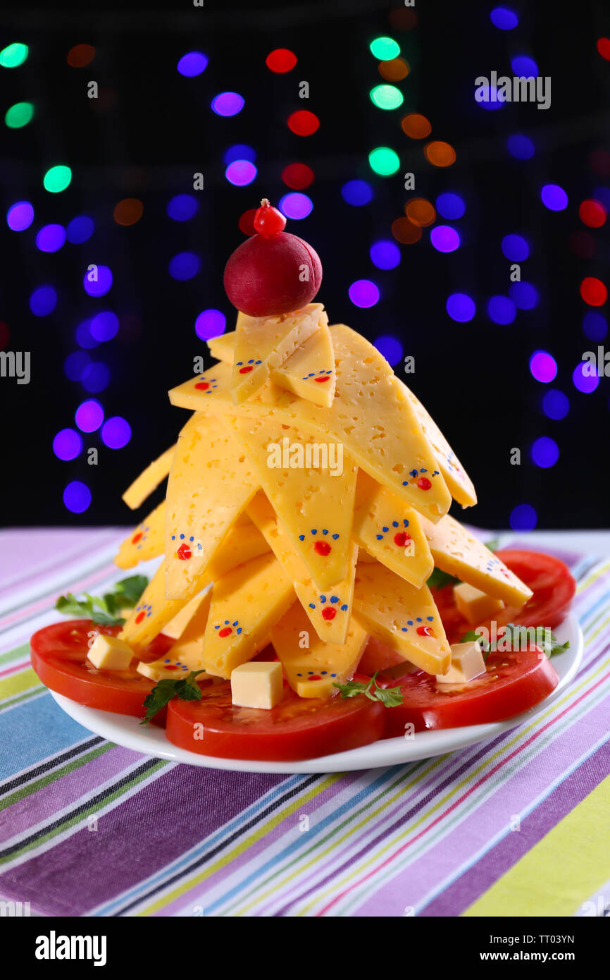 Christmas tree from cheese on table on dark background Stock Photo