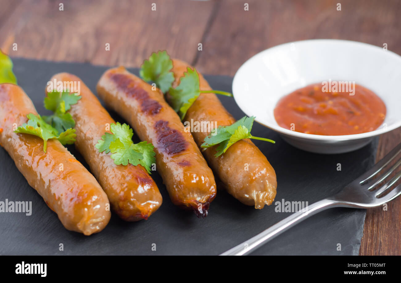 delicious pork fried sausages served with herbs and sauce Stock Photo