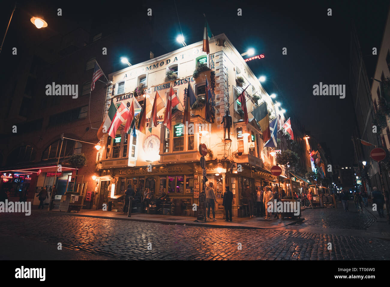 Dublin, Ireland - September 2018. View of an Irish pub with flags and lights at night, located on the corner of the street. Stock Photo