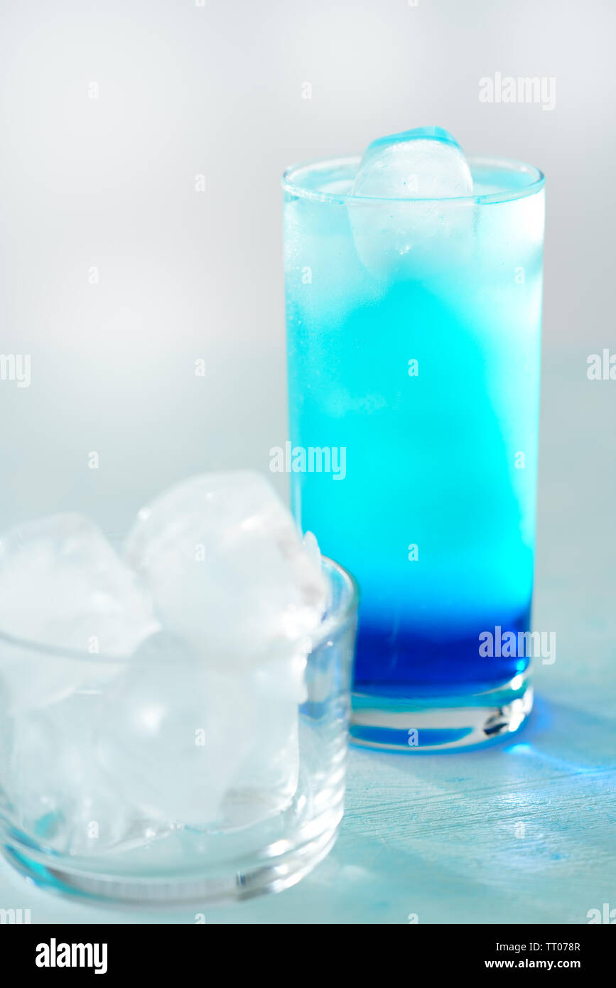 https://c8.alamy.com/comp/TT078R/blue-lagoon-cocktail-is-a-collins-glass-light-blue-background-real-ice-high-resolution-TT078R.jpg