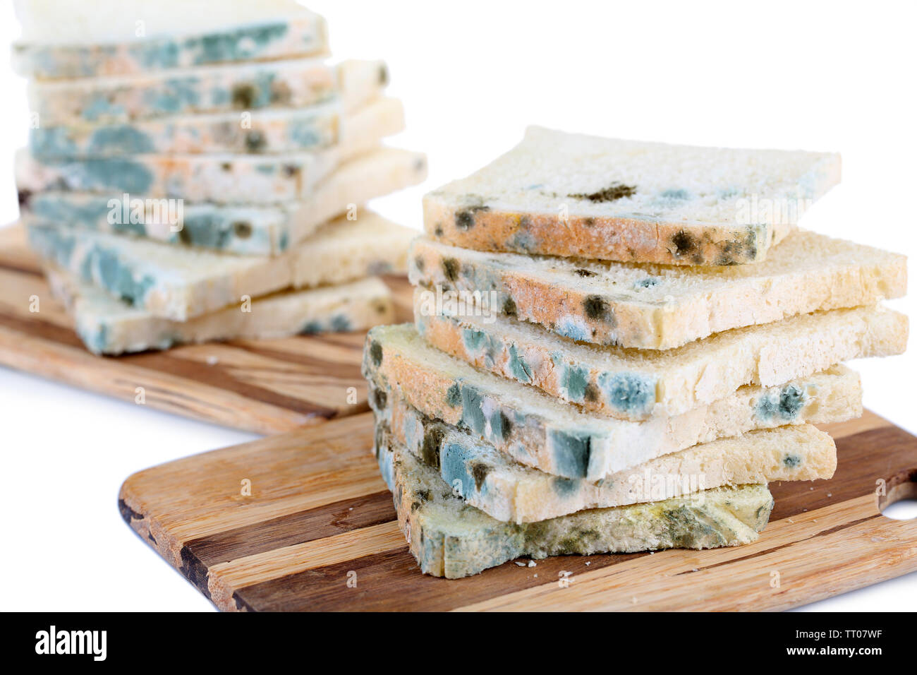 Mouldy bread on cutting board, isolated on white Stock Photo