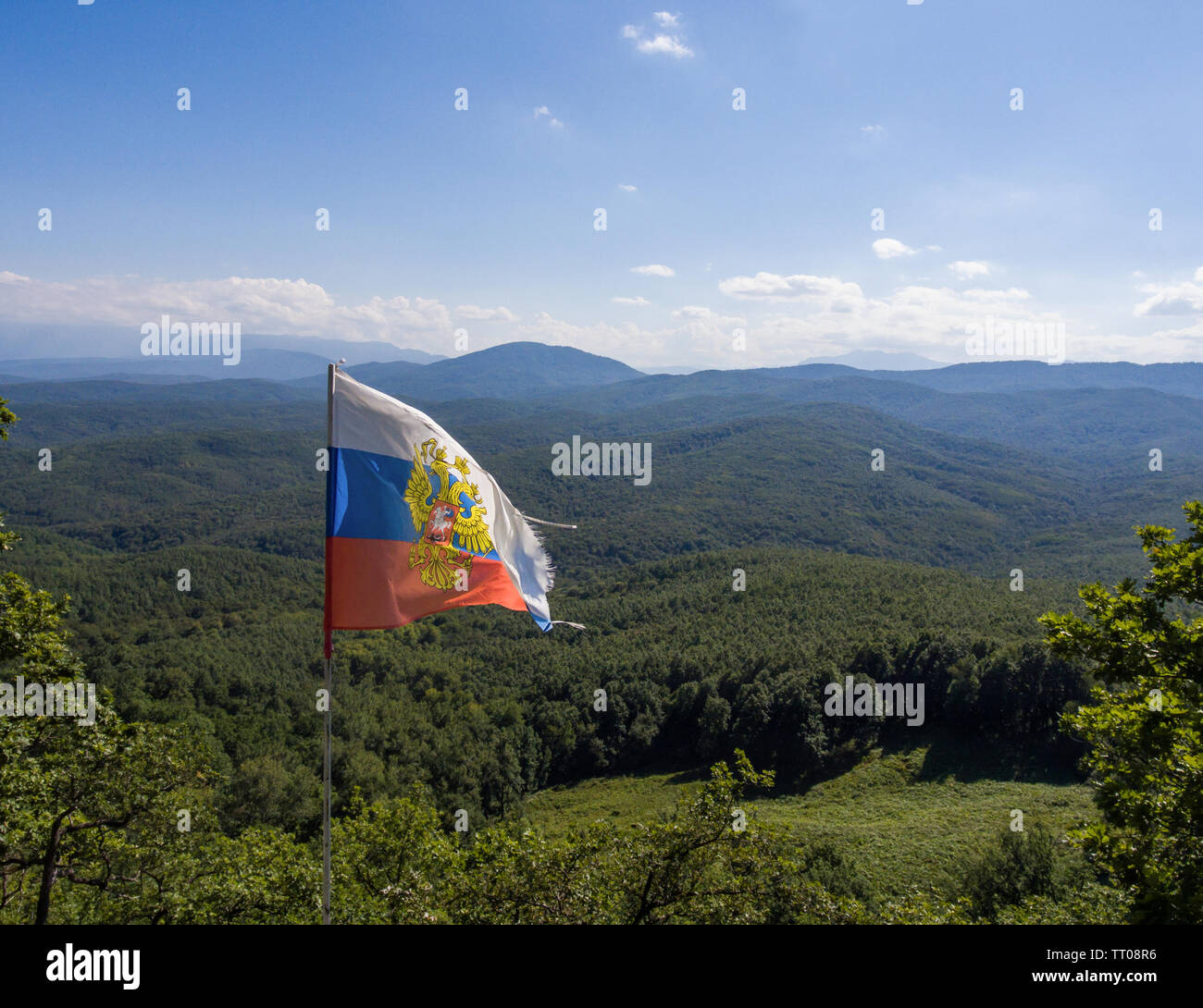 Caucasian mountain landscape on the background of Russian flag. Stock Photo