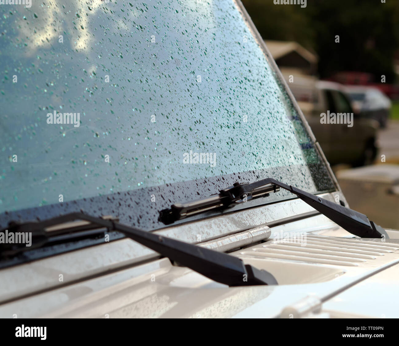 Raindrops on the outside of the windshield of a white Jeep Wrangler. Stock Photo