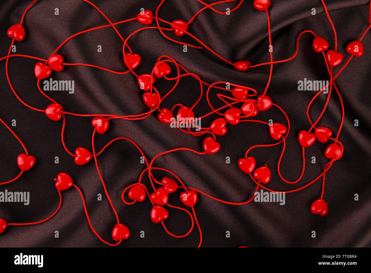 Heart-shaped beads on string on fabric background Stock Photo - Alamy