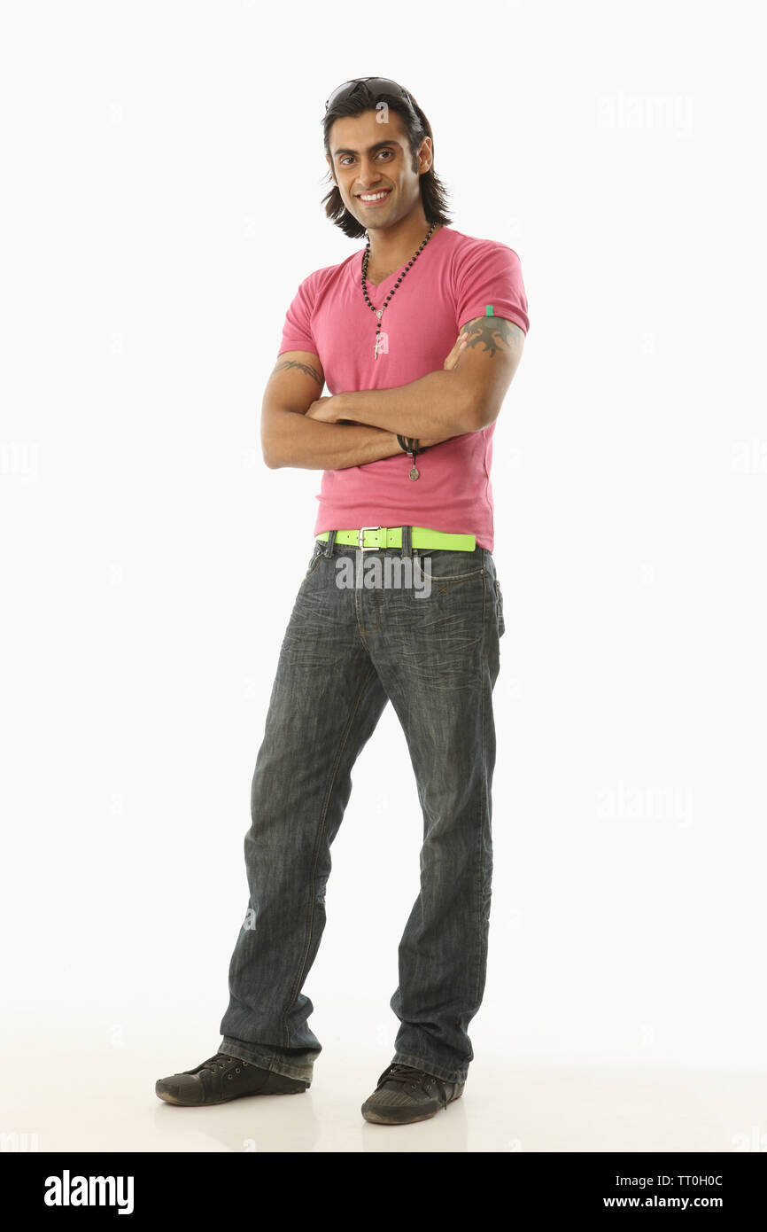 Indian young man standing with his arms crossed Stock Photo - Alamy