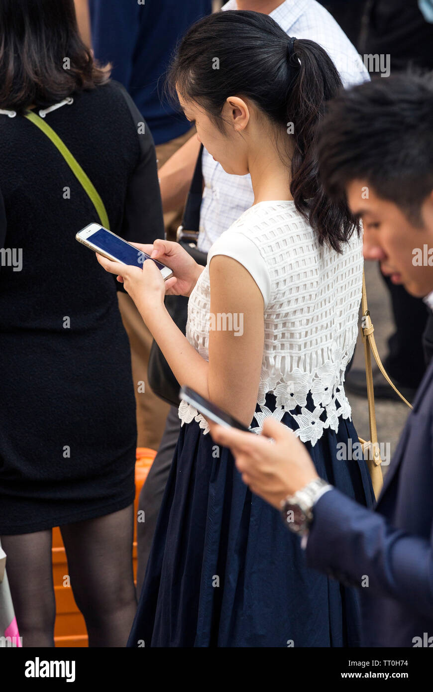 Pedestrians concentrating on mobile phones in the street, Hong Kong, SAR, China Stock Photo