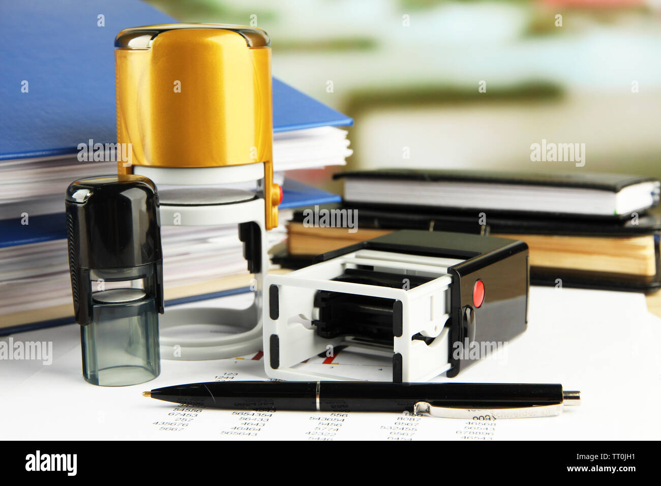 Stamps with notepads and papers on table on bright background Stock Photo