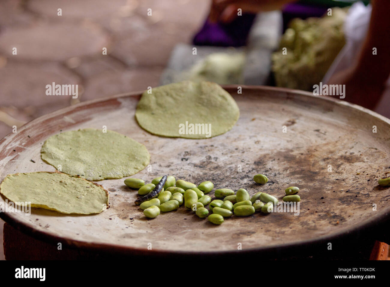 cooking tortillas on a mexican three stone stove fired by wood and