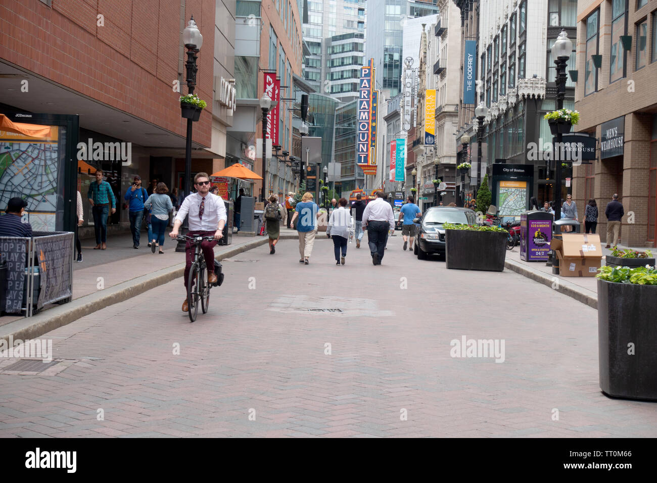 People walking and biking on Washington Street in Boston Massachusetts with neon sign for the Paramount Theater Stock Photo