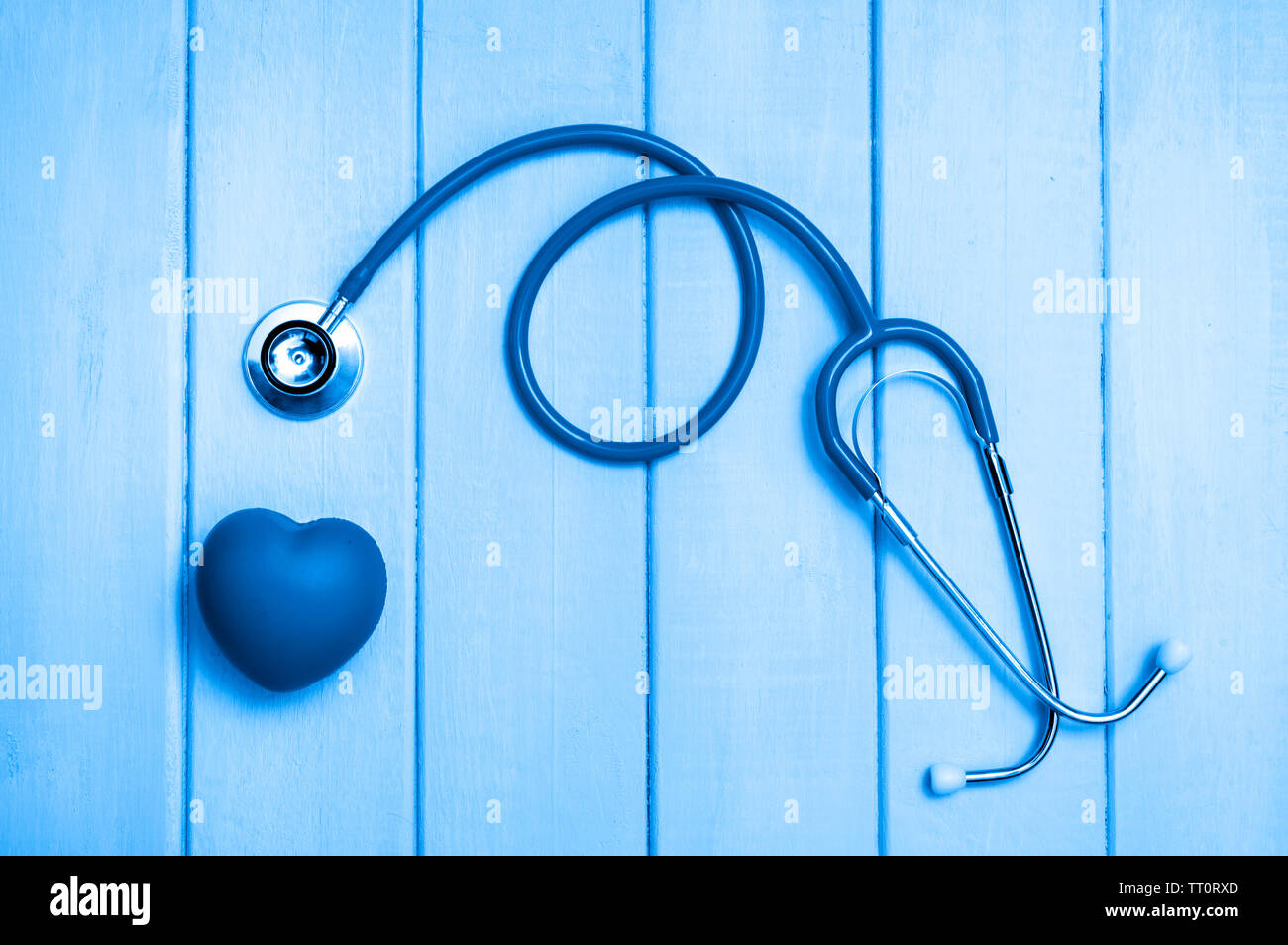 Stethoscope and heart on wooden background. Blue tonned Stock Photo - Alamy