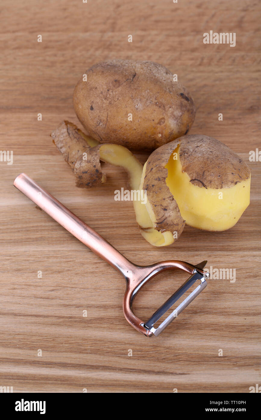 https://c8.alamy.com/comp/TT10PH/peeler-and-fresh-potato-on-wooden-background-TT10PH.jpg