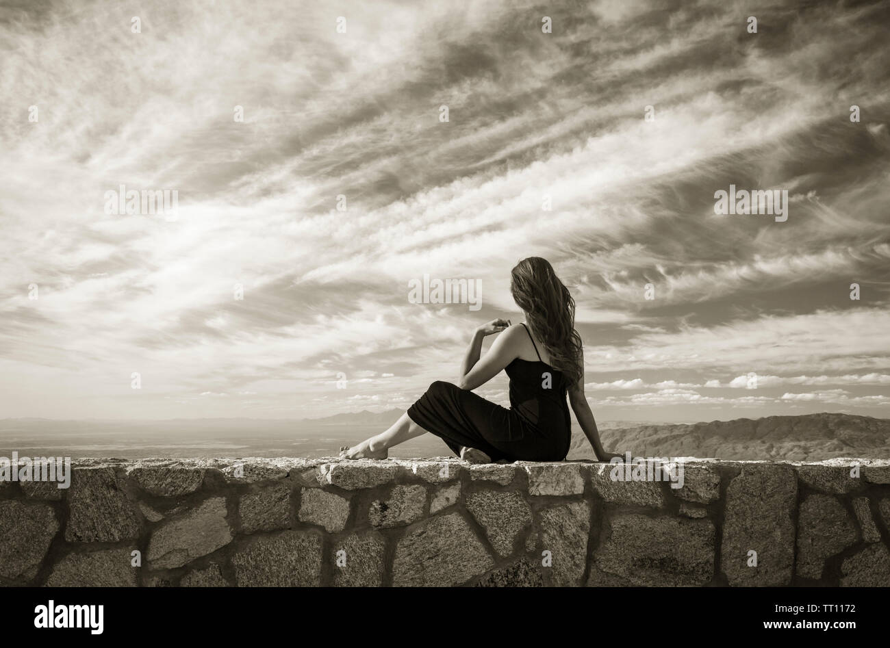 Beautiful, healthy young woman looking out at vast landscape. Beauty, health, wellness concepts. Stock Photo
