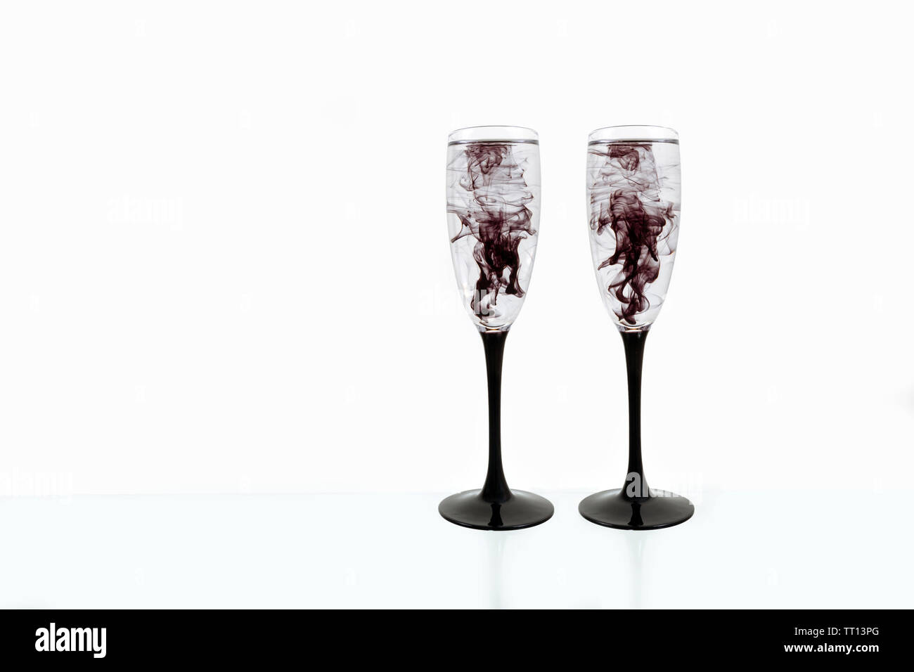 Two Wine glasses on white background with black color paints inside
