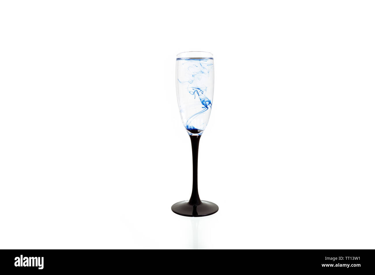 Wine glass on white background with blue color paints inside. Fougere