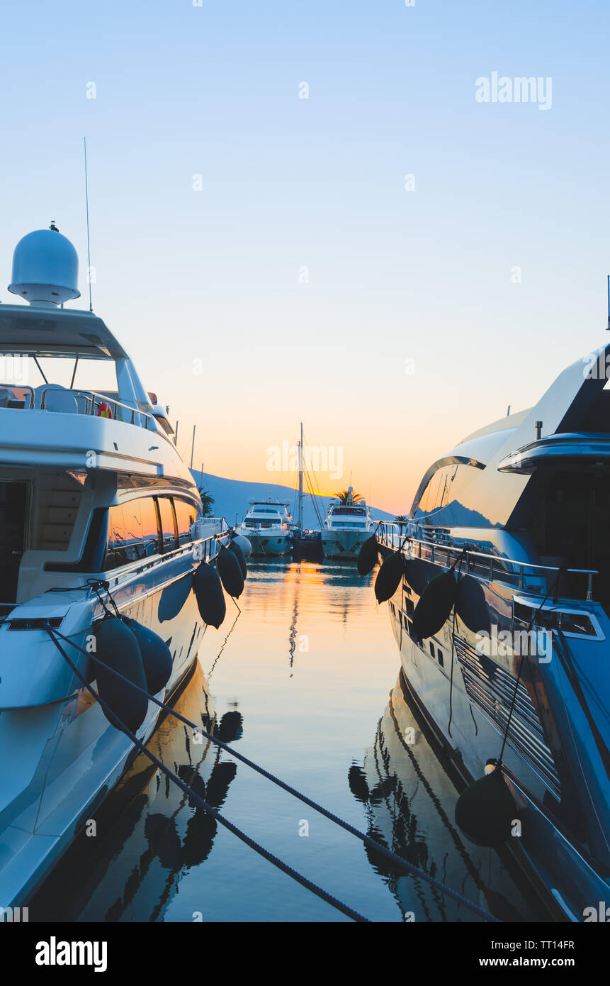Yachts moored in the port on the background of the evening sunset.Swimming and travelling. Stock Photo