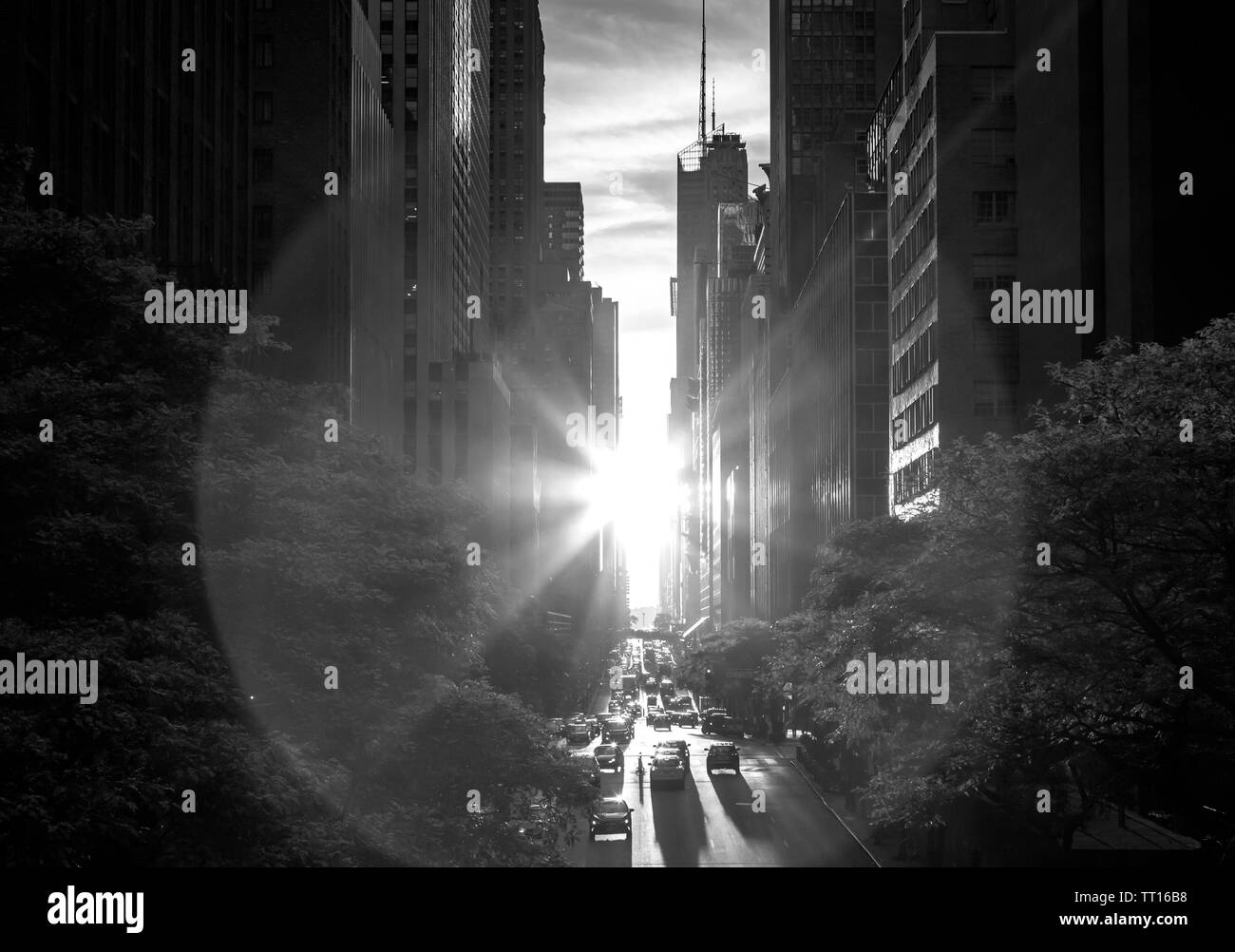 Black and white sunlight shining between the skyline buildings along 42nd Street in Midtown Manhattan, New York City Stock Photo