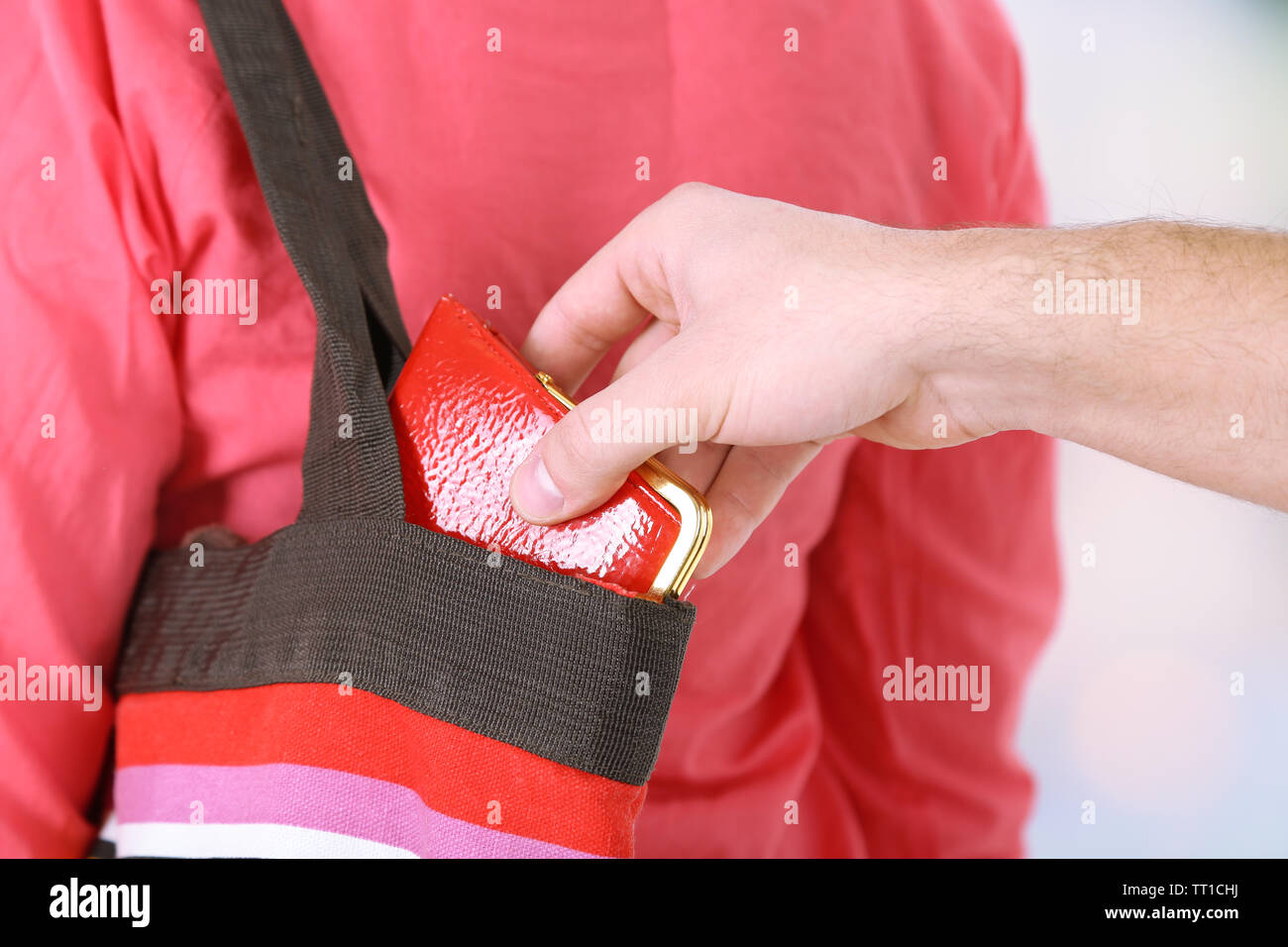 Pickpocket are stealing wallet from bag, close up, on light background Stock Photo