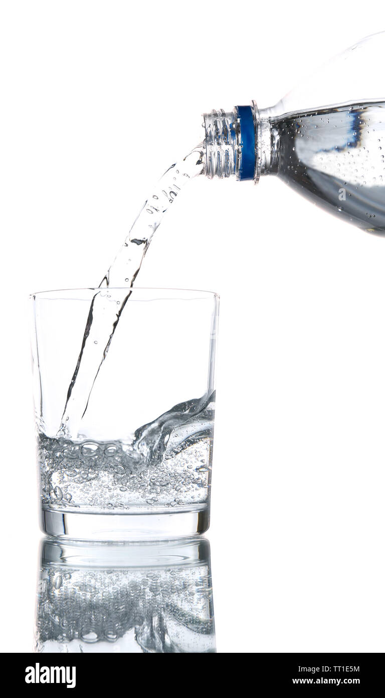 Pour water from bottle into glass, on light blue background Stock Photo