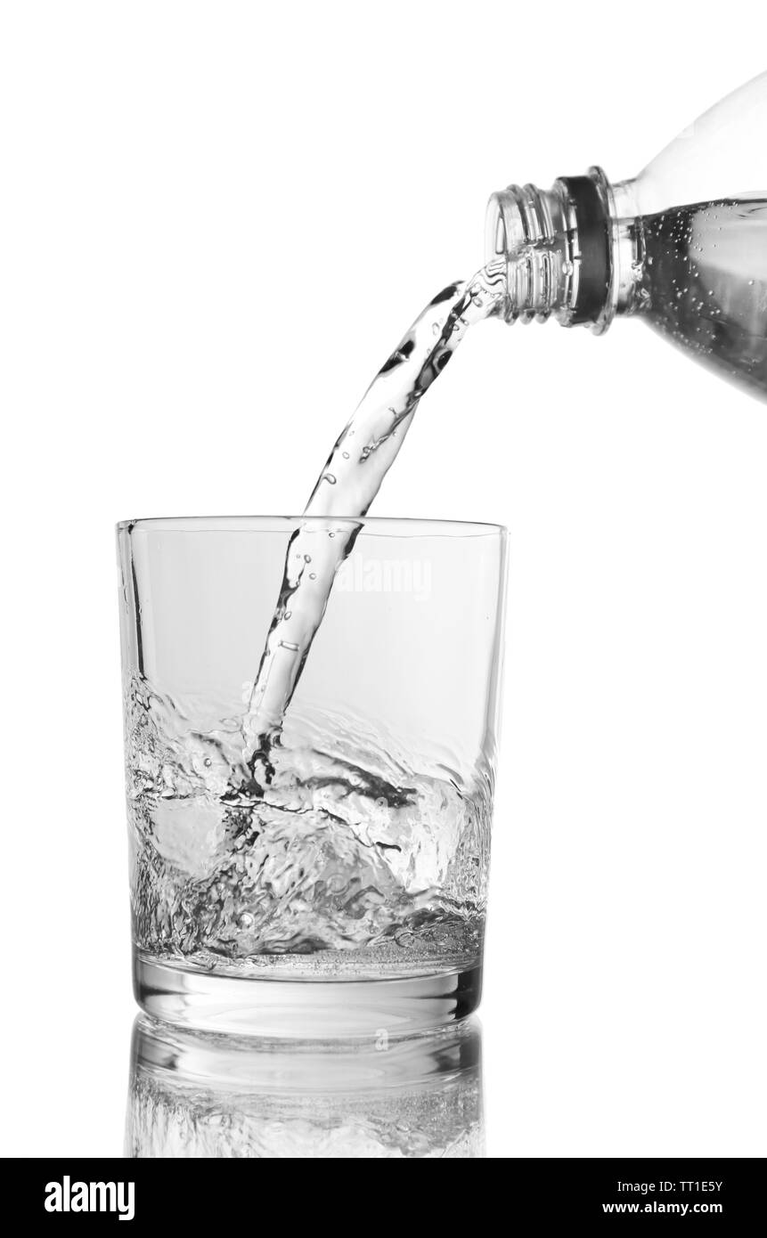 Pour water from bottle into  glass, on light blue background Stock Photo