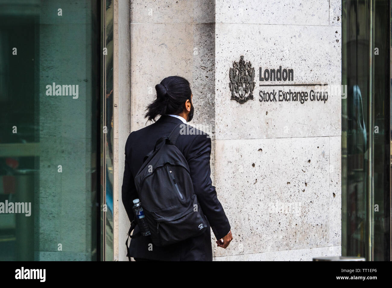 London Stock Exchange - a City worker passes the London Stock Exchange building at 10 Paternoster Row in the City of London Financial District Stock Photo