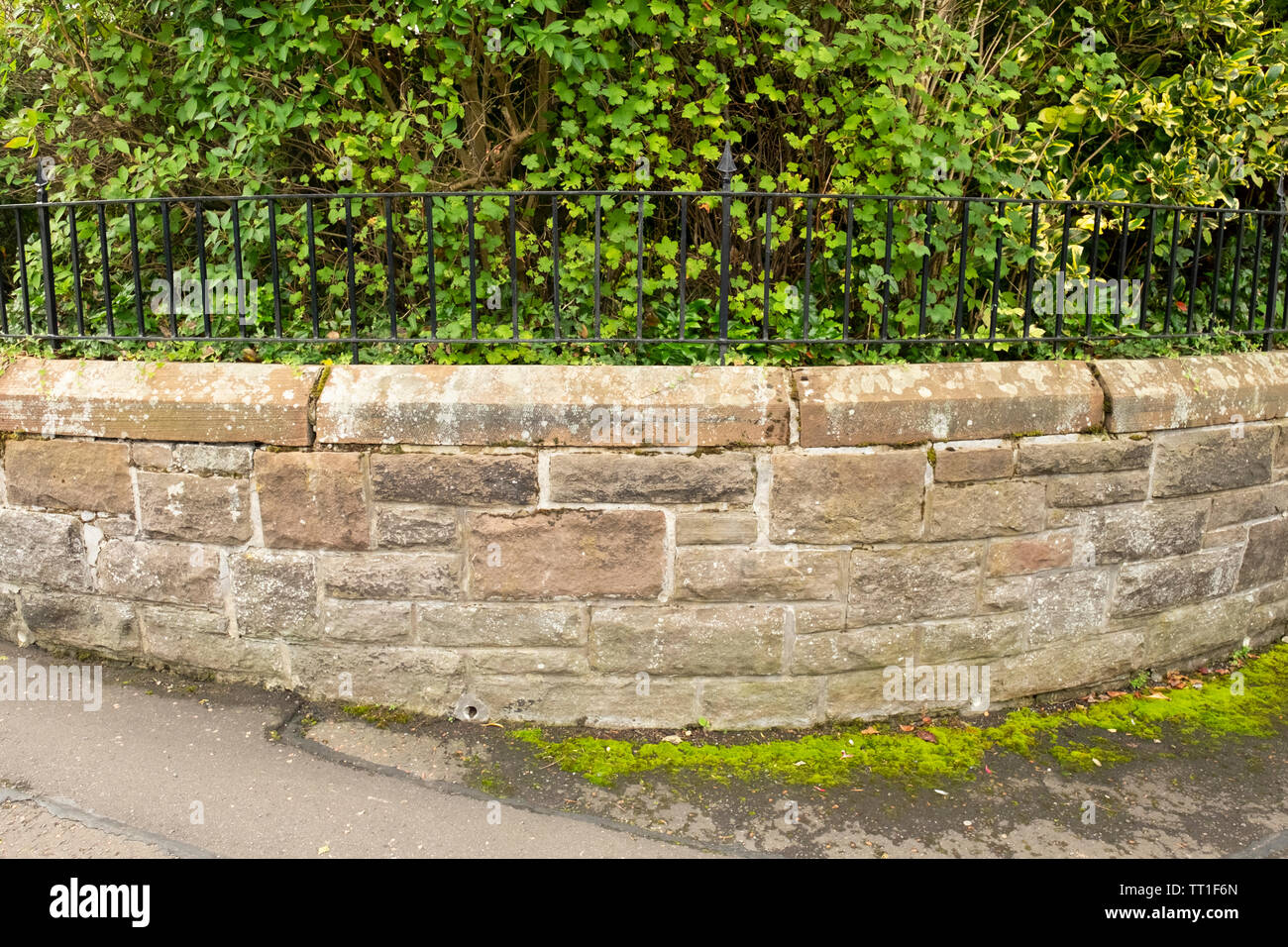 Low stone wall and metal fence outside garden, in the Victorian suburb ...