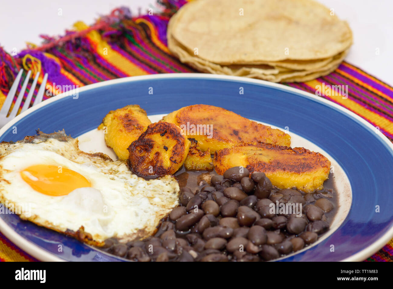 mexican tropical breakfast, made with plantains, eggs and black beans with tortillas, copy space Stock Photo