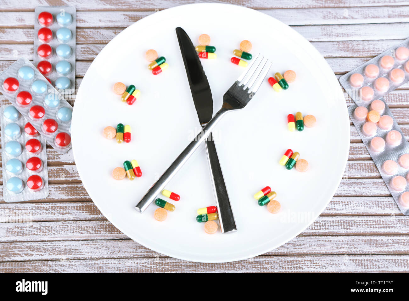 Medication schedule and meals. Conceptual photo. On wooden background ...