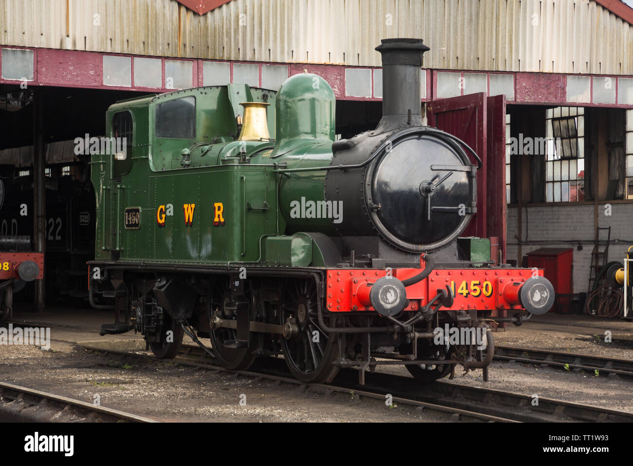 Green GWR 1450 steam railway locomotive engine (1400 class 0-4-2T built 1935 at Swindon Works) stationary by shed, Didcot Railway Centre, Oxfordshire. Stock Photo