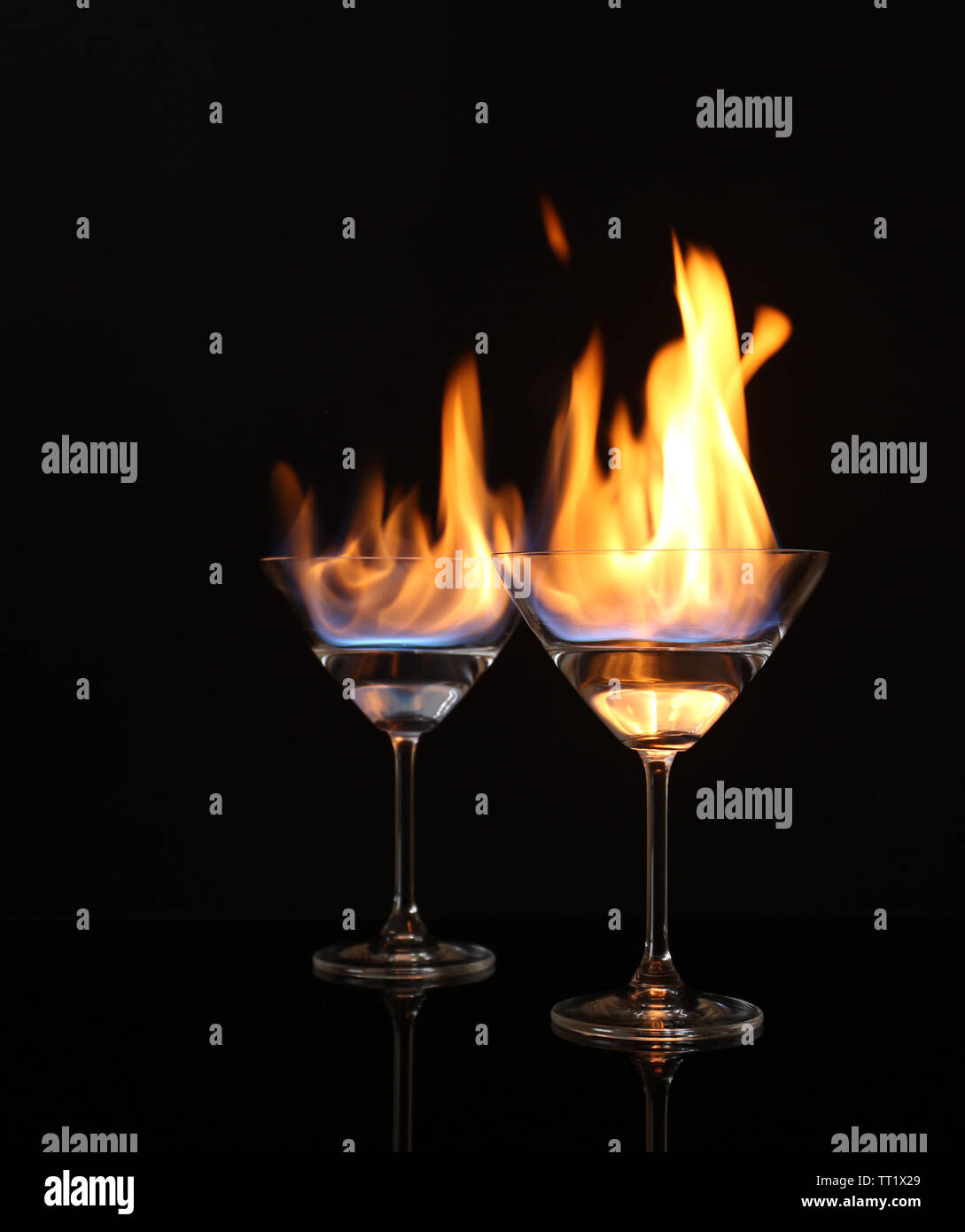 Glasses with burning alcohol on black background Stock Photo - Alamy