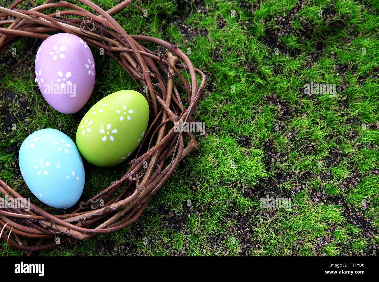 Easter eggs in nest on green grass background Stock Photo - Alamy