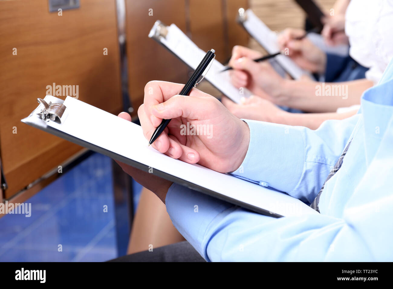 Hands holding pens and making notes at conference Stock Photo - Alamy
