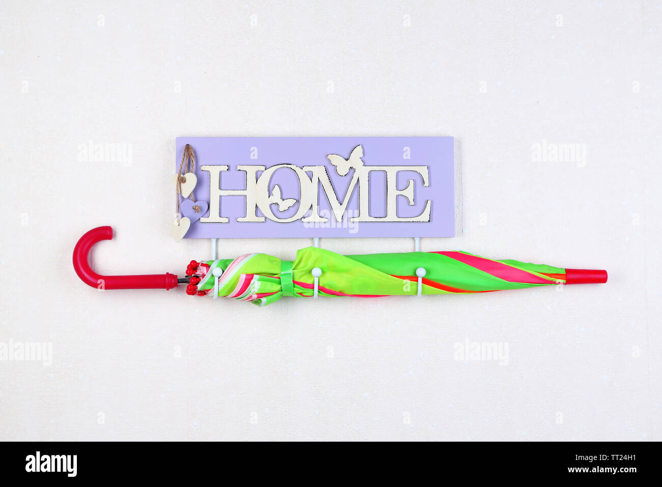 Umbrella hanging from hook, on light wall background Stock Photo Alamy